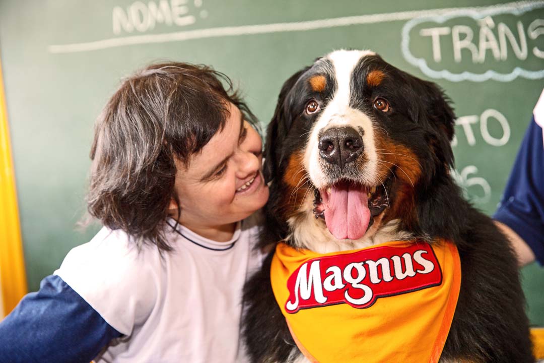 Aluno ao lado do cão Magnus, mascote do Instituto Adimax, em um Centro de Educação Especial.