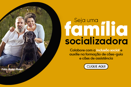 Na imagem um casal com seu cão em socialização, junto do texto Seja uma família socializadora! Colabore com a inclusão social e auxilie na formação de cães-guia e cães de assistência