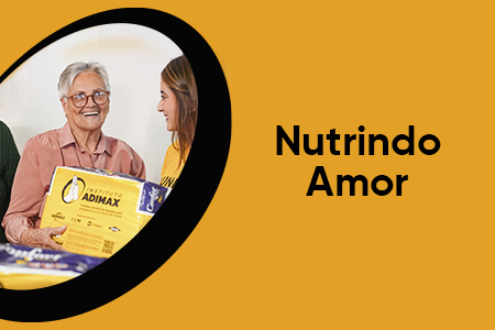 Na imagem, uma colaboradora do Instituto Adimax entrega um pacote de fralda para duas senhoras de um asilo, doação do programa Nutrindo Amor